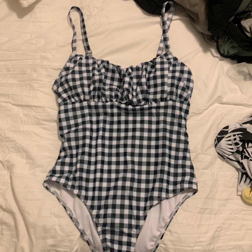 One piece bathing suit, never used, has pads in bra